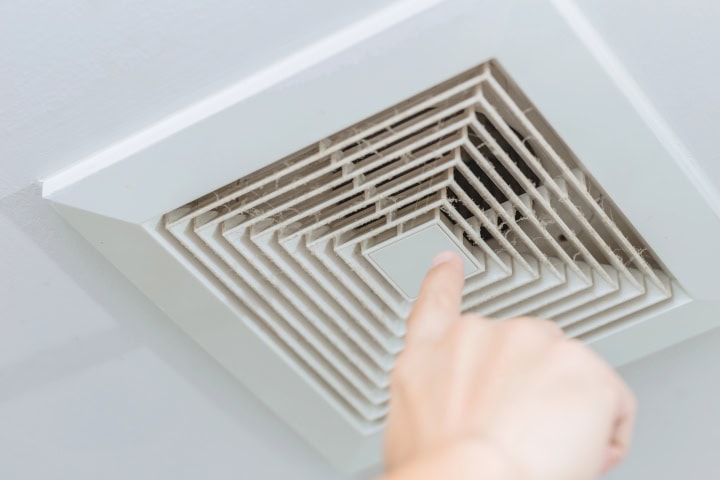 Office Making Employees Sick: finger pointing at dusty ceiling vent