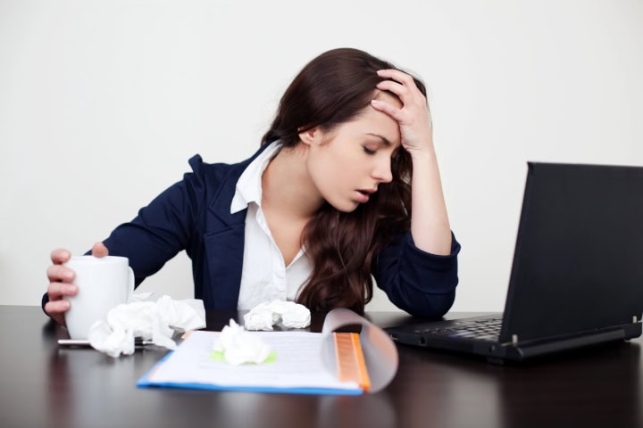 office making employees sick: sick young woman at desk used kleenex on desk