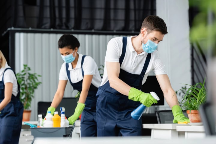 cleaners in masks cleaning office