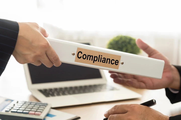 Cleaning Compliance for Healthcare & Industrial Facilities - hands passing compliance manual